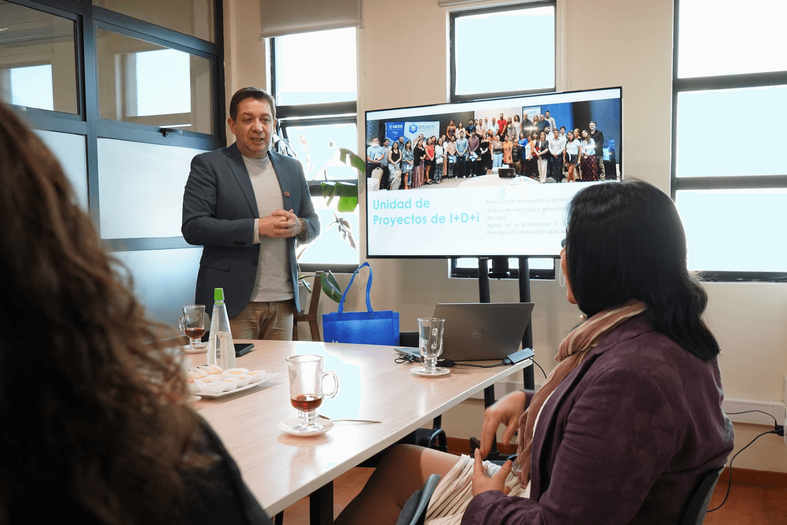 Un profesional presenta un proyecto frente a un grupo de personas en una sala de reuniones.
