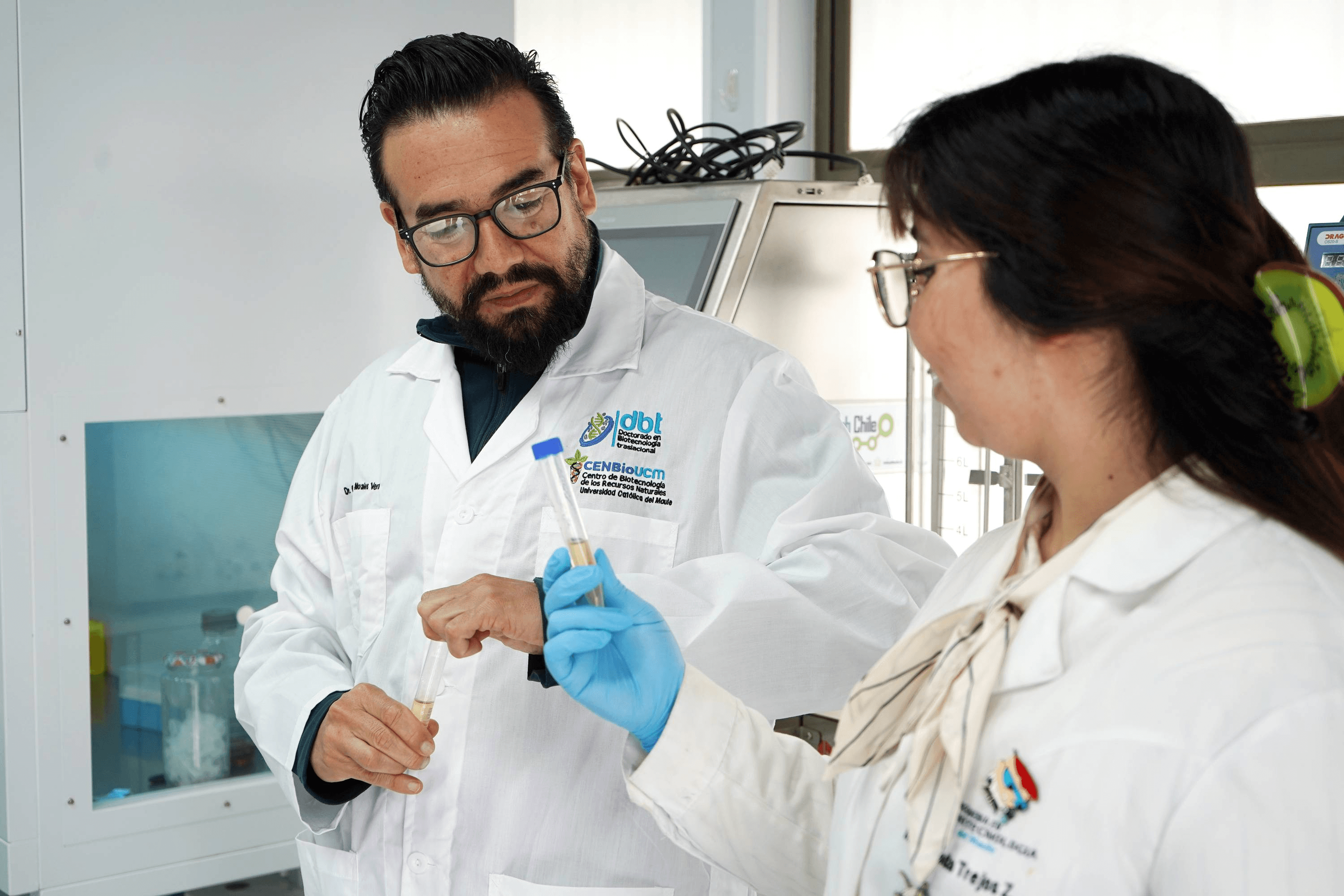 Dos profesionales de la salud conversan mientras realizan un análisis en un laboratorio.